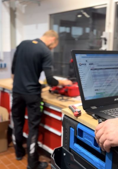 Digitale Prüfprozesse bei PGZ GmbH: Techniker bei der Geräteprüfung und Dokumentation per Software und Laptop